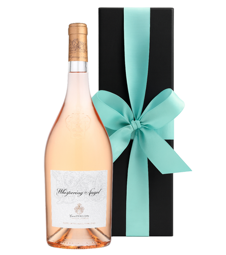 Bottle of Whispering Angel rosé wine with a turquoise ribbon on a black box against a white background